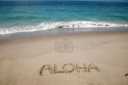 Foto de La palabra ALOHA escrita en la arena de la playa de Hawai. - Imagen libre de derechos