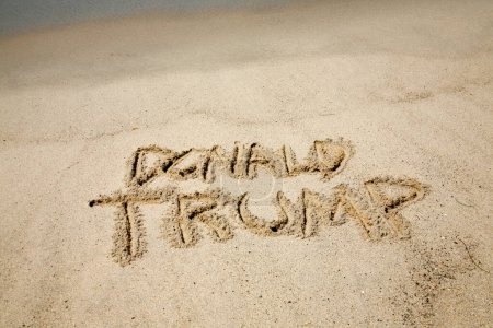 Téléchargez les photos : Washington DC. - États-Unis - 18 août 2023 : Donald Trump. Le nom Donald Trump écrit dans le sable avec l'océan Pacifique. Le nom du président Donald Trump écrit dans le sable. Président Trump. - en image libre de droit
