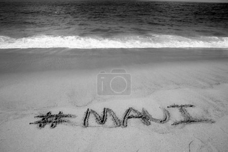 Téléchargez les photos : Le nom # Maui écrit en sable sur la plage avec l'océan Pacifique Arrière-plan. - en image libre de droit