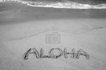 Foto de La palabra ALOHA escrita en la arena de la playa de Hawai. - Imagen libre de derechos