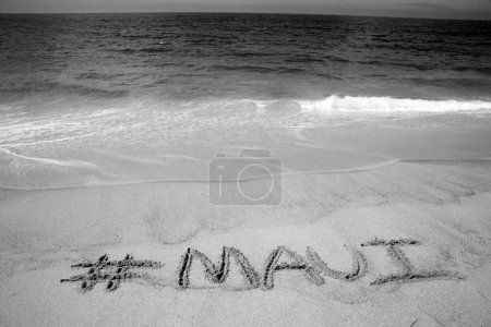 Photo for The name # Maui written in sand on the beach with the Pacific Ocean Background. - Royalty Free Image