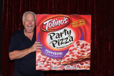 Photo for Lake Forest, California - USA - January 16, 2016: Photo Booth. A man smiles as he holds a GIANT Box of TOTINO'S Pepperoni Pizza while in a Photo Booth. - Royalty Free Image