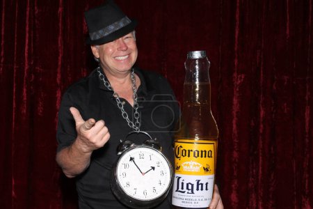 Téléchargez les photos : Lake Forest, Californie - États-Unis - 15 mai 2016 : Un homme avec horloge tient une bouteille de bière Corona gonflable alors qu'il sourit et pose pour que ses photos soient prises dans une cabine photo - en image libre de droit