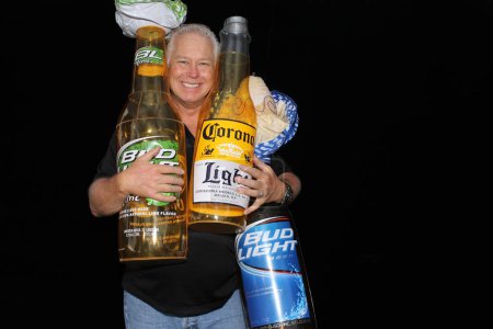 Téléchargez les photos : Lake Forest, Californie, États-Unis - Le 15 mai 2016 : Un homme tient une bouteille de bière Corona gonflable alors qu'il sourit et pose pour que ses photos soient prises dans une cabine photo. - en image libre de droit