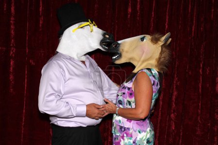 Téléchargez les photos : Les personnes non identifiables portent des masques de tête de cheval et posent et jouent pendant que leurs photos sont prises dans une cabine photo - en image libre de droit