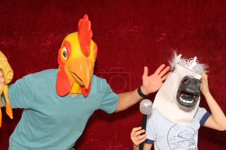 Téléchargez les photos : Deux personnes portent des masques pour animaux et posent pour des photos dans une cabine photo - en image libre de droit