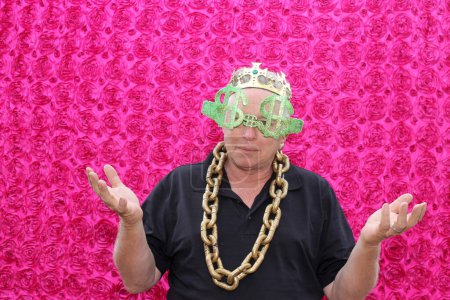 Photo for A man wears crazy props and poses for his picture to be taken in a photo booth at a party - Royalty Free Image
