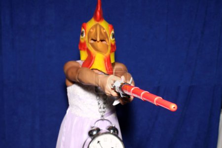 Photo for A person wears a Rubber Chicken Head Mask while posing for pictures in a Photo Booth - Royalty Free Image