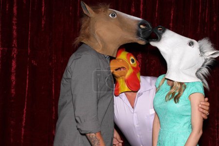 Photo for Unidentifiable People wear Horse and Chicken Head Masks and pose and play while their pictures are taken in a Photo Booth. Party Photo Booth. Wedding Photo Booth. Horsing Around. Funny. - Royalty Free Image