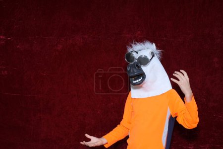 Foto de Persona no identificable usar máscara de cabeza de caballo y posar en una cabina de fotos. - Imagen libre de derechos
