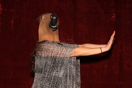 Photo for Unidentifiable person wears Horse Head Mask and pose while their pictures are taken in a Photo Booth. Party Photo Booth. - Royalty Free Image