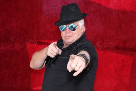 Téléchargez les photos : Homme élégant en chapeau noir et lunettes de soleil pose pour sa photo à prendre lors d'une photomaton à une fête. - en image libre de droit