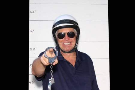 Photo for Photo Booth. Motorcycle Police Officer in front of a Police Booking Sign. - Royalty Free Image