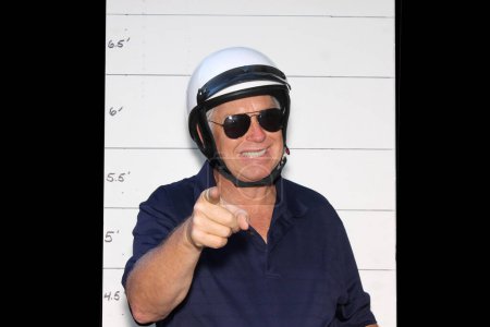 Téléchargez les photos : Photo Booth. Police de moto devant un panneau de réservation de la police. - en image libre de droit