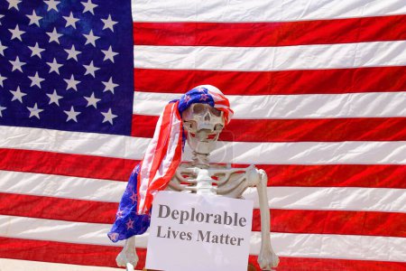 Téléchargez les photos : Squelette humain tenant des vies déplorables signe Matter dans un photomaton - en image libre de droit