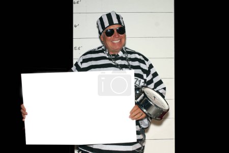 Photo for A man wears a Prison Striped Uniform with blank paper border in front of a Police Mugshot Chart . - Royalty Free Image