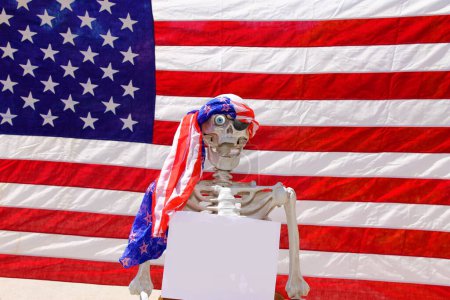 Foto de Esqueleto humano sosteniendo un póster de papel en blanco en una cabina de fotos - Imagen libre de derechos