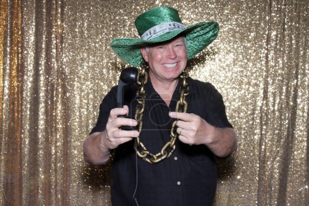Photo for Man in big golden chain and green money hat posing in photo booth - Royalty Free Image