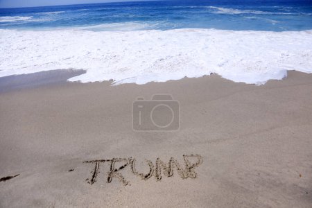 Téléchargez les photos : Il Nom TRUMP écrit dans le sable sur la plage. - en image libre de droit