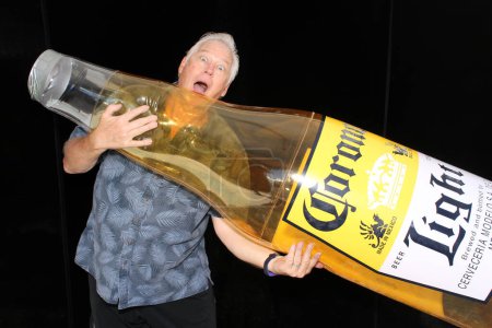 Téléchargez les photos : Lake Forest, Californie - États-Unis - 15 mai 2016 : Un homme tient une bouteille de bière Corona gonflable alors qu'il sourit et pose pour que ses photos soient prises dans un photomaton - en image libre de droit