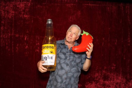 Téléchargez les photos : Lake Forest, Californie - États-Unis - 15 mai 2016. Un homme tient une bouteille de bière Corona gonflable pendant qu'il sourit et pose pour que ses photos soient prises dans une cabine photo. - en image libre de droit