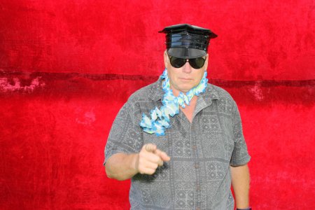 Téléchargez les photos : Un homme vêtu d'une chemise grise et de lunettes de soleil et d'un chapeau noir. - en image libre de droit