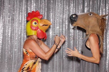 Téléchargez les photos : Deux personnes portent des masques pour animaux et posent pour des photos dans une cabine photo - en image libre de droit