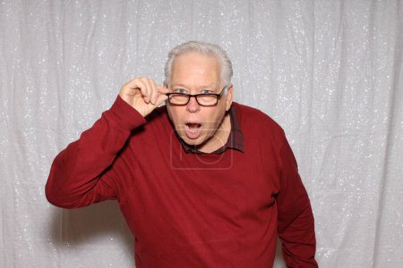 Photo for Photo Booth. A man shocked  and poses while in a Photo Booth at a Party. Photo Booth with a white sequin background. - Royalty Free Image
