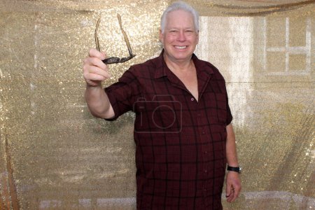 Photo for A man Smiles and Poses for his pictures to be taken while in a Photo Booth at a Wedding or Party. - Royalty Free Image