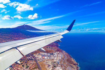 Foto de Vista aérea del cielo sobre las montañas y el pico del volcán Teide desde la ventana de un avión.Islas Canarias, Tenerife, España.Paisaje urbano sobre las nubes. - Imagen libre de derechos