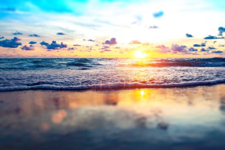 Téléchargez les photos : Plage de sable et coucher de soleil sur le rivage.Beau paysage nuageux sur la mer. - en image libre de droit