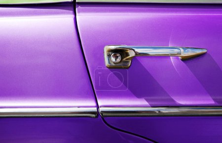 Foto de Detalle de una puerta de coche vintage en tono morado. Pasatiempos automotrices y coches clásicos. - Imagen libre de derechos
