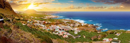 Spaniens Strände. Sonnenuntergang Panorama Dorf Küste und Feld von Bananenbäumen auf Teneriffa. Sehenswürdigkeiten und Tourismus auf den Kanarischen Inseln.