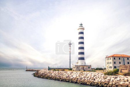 Photo for Small lighthouse in Lido de Jesolo in cloudy weather at the sea passage - Royalty Free Image