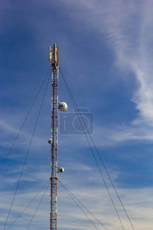 Téléchargez les photos : Tour de télécommunication pour téléphone portable avec antennes sur un ciel bleu. Fonction de distribution des téléphones mobiles contractuels. - en image libre de droit