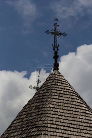Photo for Old wooden church against the blue sky in Ukraine, wooden roof with a cross. - Royalty Free Image