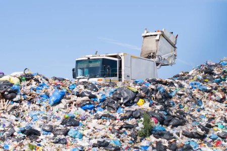 Landfill waste disposal. Garbage truck unloads rubbish in landfill.  Stickers 624717800