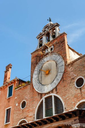 Large 15th-century clock above the entrance of the Church of San Giacomo di Rialto in Venice, Italy. The amazing clock divided into 24 hours. The church is a popular tourist attraction of Europe.