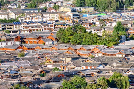 Téléchargez les photos : Vue aérienne des toits traditionnels chinois en tuiles noires de maisons authentiques dans la vieille ville de Lijiang, en Chine. Lijiang est une destination touristique populaire de l'Asie. - en image libre de droit