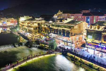 Photo for Fenghuang, China - September 23, 2017: Fabulous aerial night view of Phoenix Ancient Town and the Tuojiang River (Tuo Jiang River). Fenghuang is a popular tourist destination of Asia. - Royalty Free Image