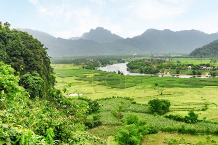 Awesome aerial view of the Son River at Phong Nha-Ke Bang National Park in Vietnam. Landscape formed by karst towers and rice fields. The national park is a popular tourist attraction of Asia.