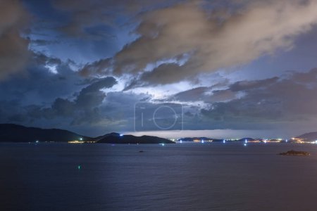 Téléchargez les photos : Ciel orageux sombre dramatique et éclair au-dessus de la baie de Nha Trang de la mer de Chine méridionale dans la province de Khanh Hoa la nuit au Vietnam. La ville de Nha Trang est une destination touristique populaire d'Asie. - en image libre de droit