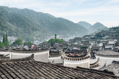 Photo for Awesome view of traditional Chinese black tile roofs of authentic buildings Phoenix Ancient Town (Fenghuang County), China. Fenghuang is a popular tourist destination of Asia. - Royalty Free Image