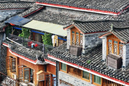 Awesome view of traditional Chinese black tile roofs of authentic buildings Phoenix Ancient Town (Fenghuang County), China. Fenghuang is a popular tourist destination of Asia.