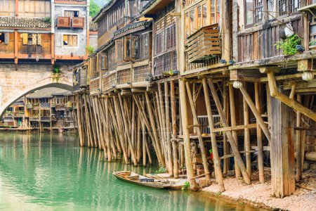 Awesome view of old authentic traditional Chinese wooden riverside houses on stilts and the Tuojiang River (Tuo Jiang River) in Phoenix Ancient Town (Fenghuang County), China.