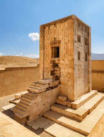 Foto de Vista del Cubo de Zoroastro sobre fondo azul del cielo en Naqsh-e Rustam en Irán. Antigua torre de piedra caliza. Cubo de Zoroastro es una atracción turística popular de Oriente Medio. - Imagen libre de derechos