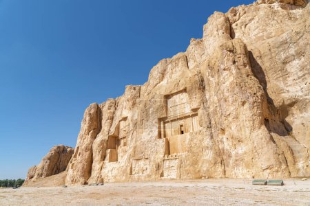 Fantastische antike Nekropole Naqsh-e Rustam auf blauem Himmel im Iran. Große Gräber achämenidischer Könige, die in beträchtlicher Höhe über dem Boden aus einer Felswand gehauen wurden.