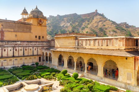 Téléchargez les photos : Vue imprenable sur le Sheesh Mahal (Palais Miroir) et le jardin verdoyant pittoresque du Fort Amer (Fort Ambre) à Jaipur, Rajasthan, Inde. Le fort de Jaigarh est visible sur la colline Aravalli en arrière-plan. - en image libre de droit