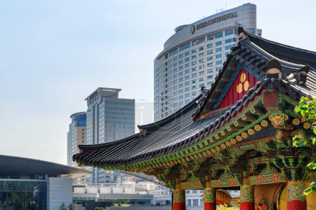 Foto de Seúl, Corea del Sur - 15 de octubre de 2017: Colorido tejado tradicional coreano de azulejos del Templo Bongeunsa y edificios modernos en el distrito de Gangnam. Templo Bongeunsa es una atracción turística popular de Asia. - Imagen libre de derechos