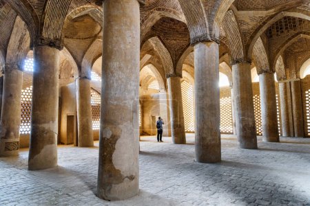 Foto de Isfahán, Irán - 23 de octubre de 2018: Antiguas columnas de sala hipóstila dentro de la mezquita Jameh. El lugar musulmán es una atracción turística popular de Oriente Medio. Increíble arquitectura islámica. - Imagen libre de derechos